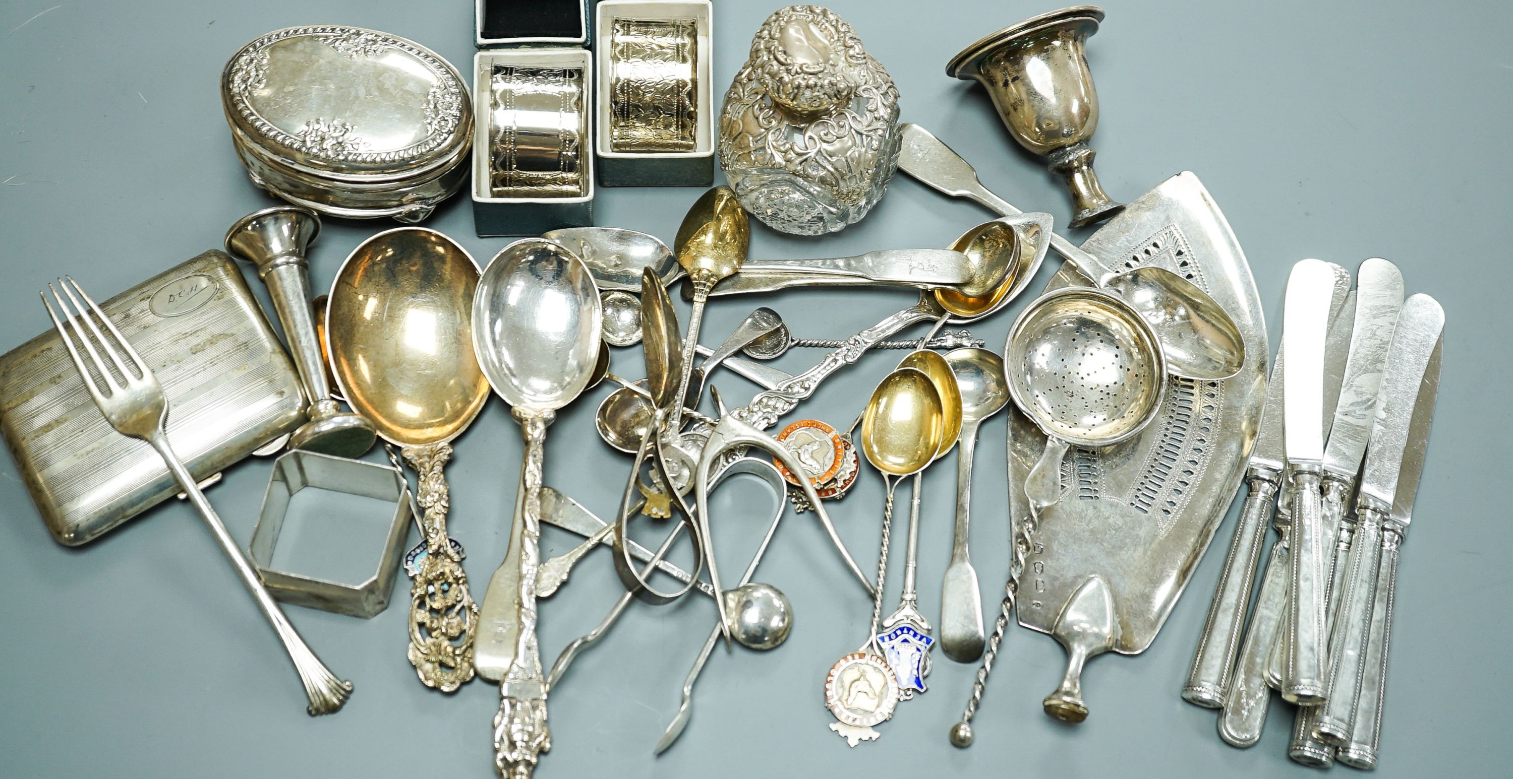 A mixed collection of sundry English and other silver to include a cigarette case, wishbone sugar nips, scent bottle, mixed cutlery, napkin rings, trinket box, etc. (some a.f.) and some plated items.